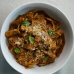 Braised short rib ragu tossed with rigatoni pasta, topped with fresh basil and grated Parmesan cheese