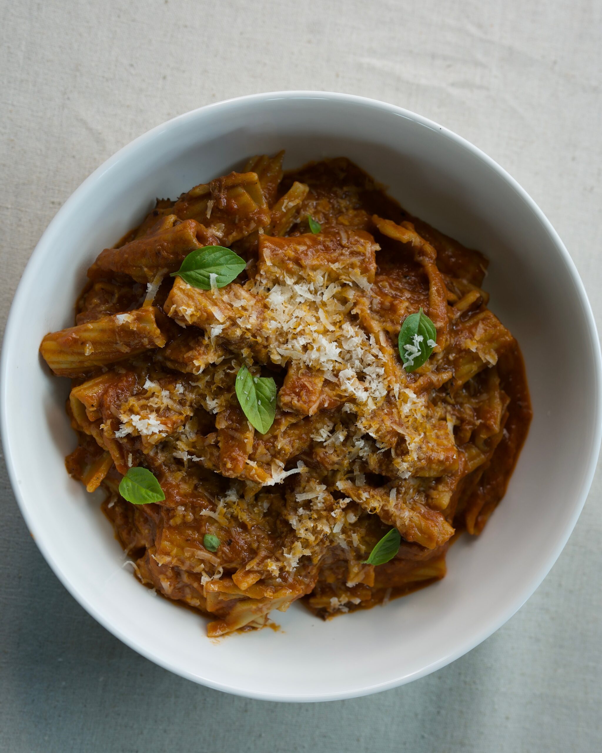 Braised short rib ragu tossed with rigatoni pasta, topped with fresh basil and grated Parmesan cheese
