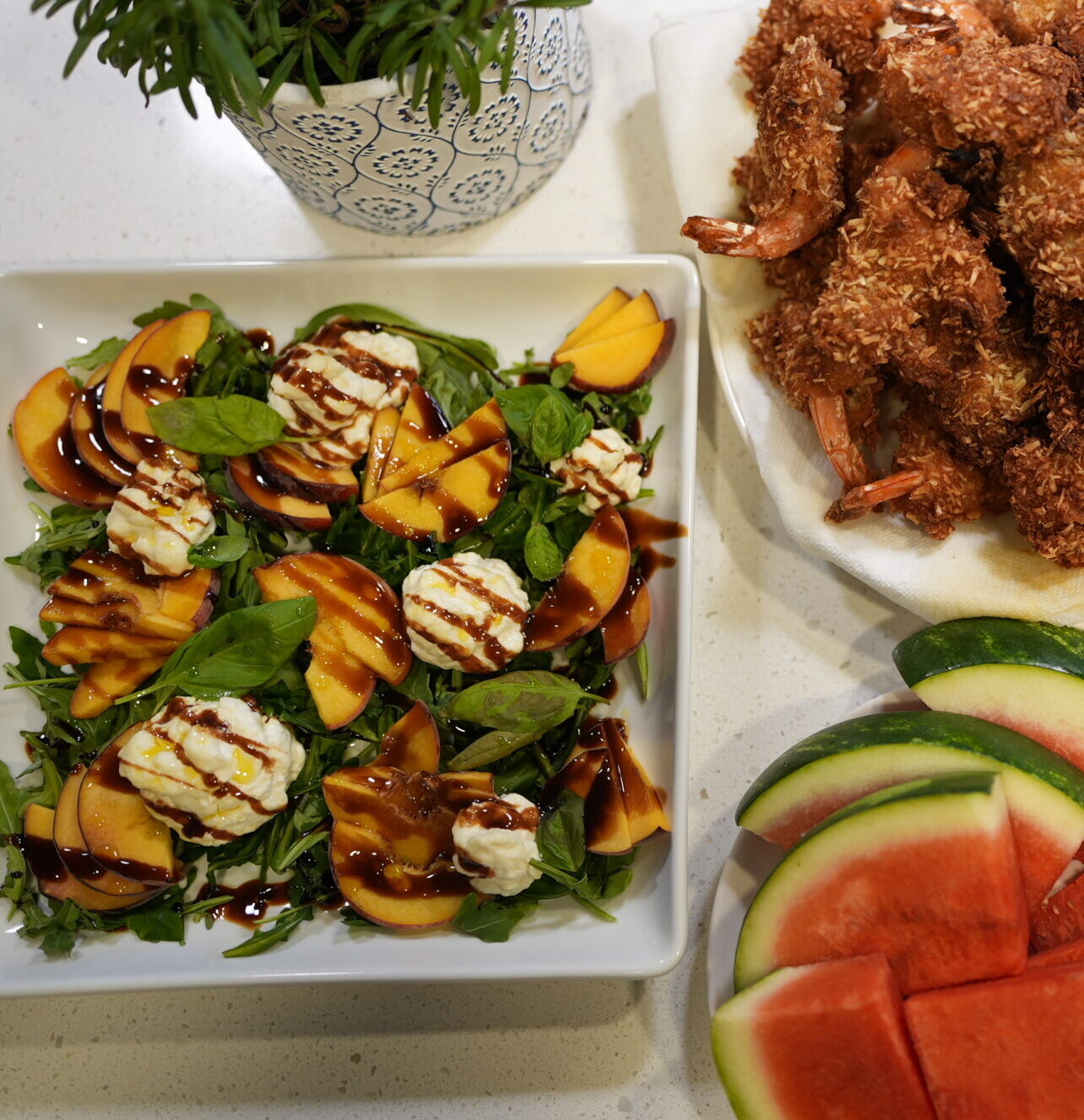 Fresh peach and burrata salad topped with basil, arugula, and drizzled with balsamic glaze.