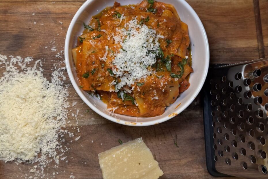 Bowl of creamy red sauce pasta topped with fresh herbs and served in a rustic dish.