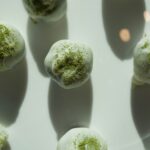 No-bake matcha protein balls dipped in white chocolate and dusted with vibrant green matcha powder – healthy high-protein snack