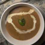 Creamy roasted butternut squash soup in bowl topped with crunchy roasted cashews, fresh parsley, garlic, and lemon – healthy fall comfort food