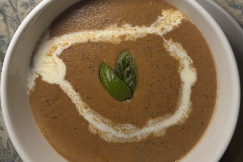 Creamy roasted butternut squash soup in bowl topped with crunchy roasted cashews, fresh parsley, garlic, and lemon – healthy fall comfort food