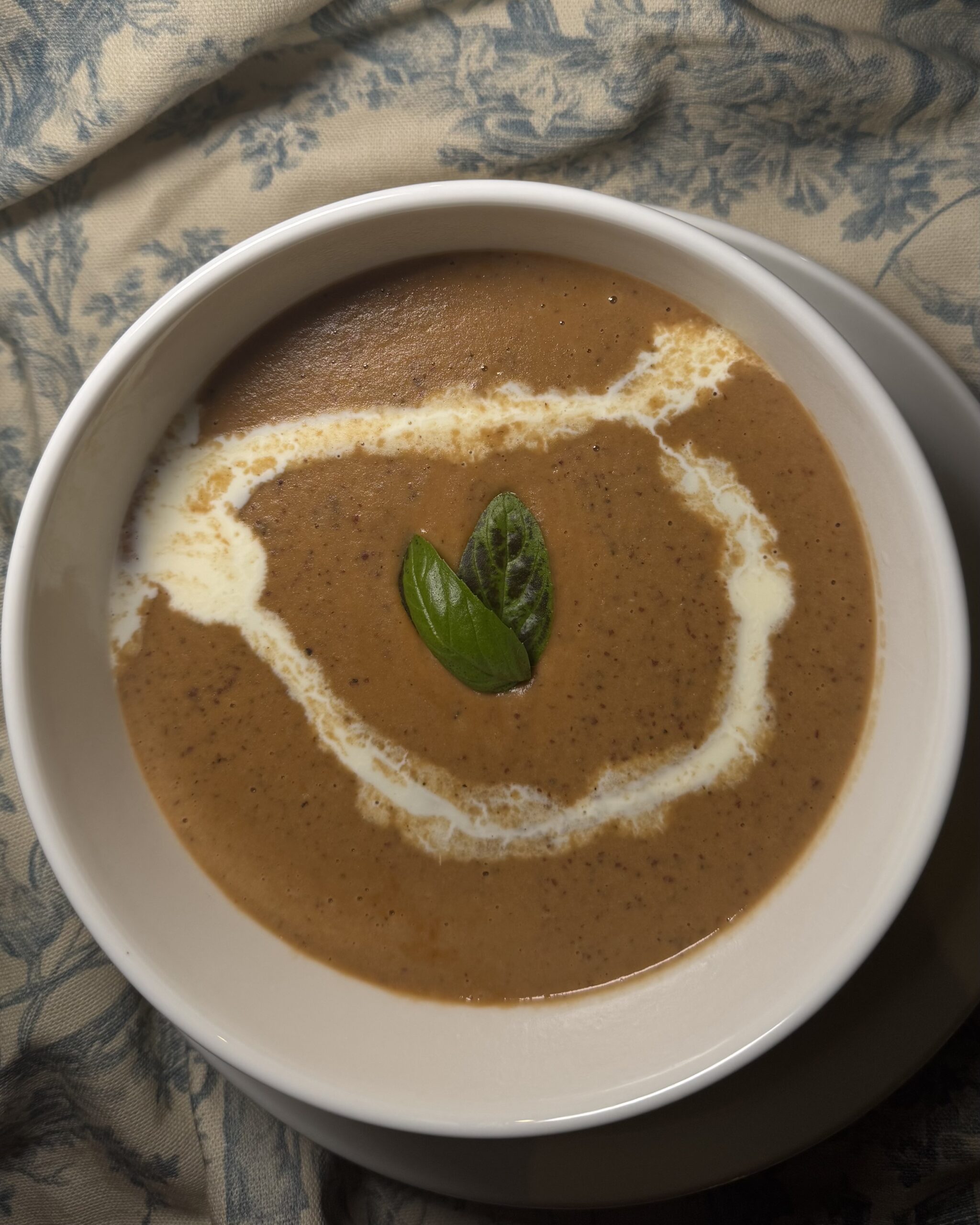 Creamy roasted butternut squash soup in bowl topped with crunchy roasted cashews, fresh parsley, garlic, and lemon – healthy fall comfort food